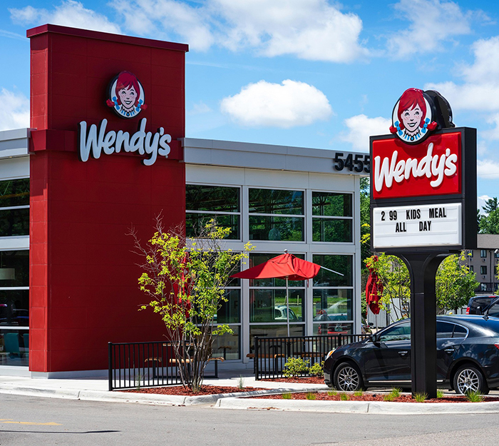 Wendy's Restaurant Exterior en un día soleado, con su letrero y área de patio.