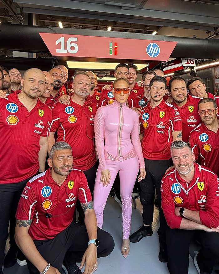 Persona en rosa Catsuit con el equipo de Ferrari en la carrera saudi F1.