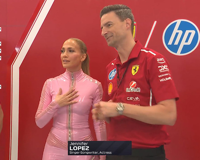 Jennifer López con un traje de gato rosa en la carrera saudita de F1, de pie con un hombre con una camisa roja de Ferrari.