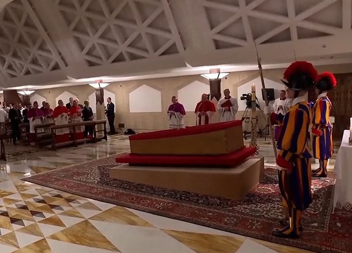 El ataúd abierto del Papa Francisco rodeado de clérigos y guardias en el Vaticano.