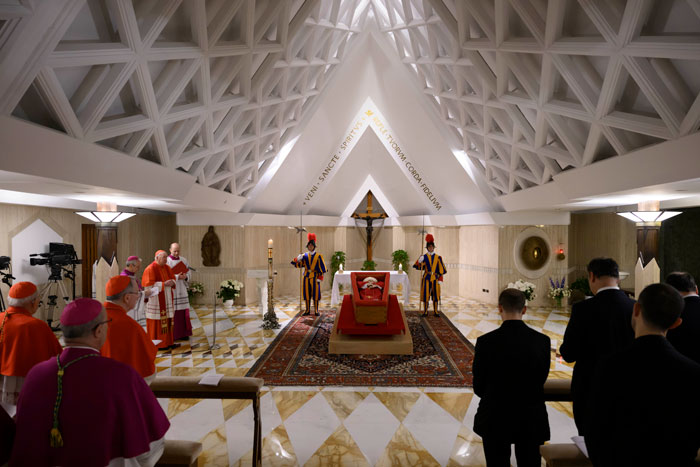 El Papa Francisco en el ataúd abierto en el Vaticano, rodeado de clérigos y guardias suizos en la capilla.