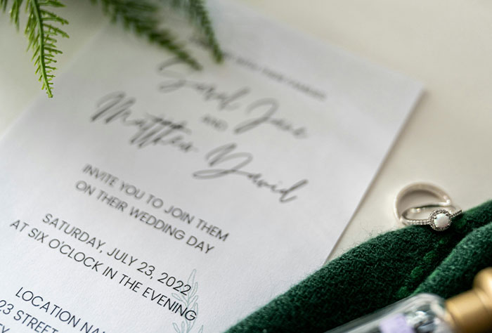Invitación de boda con anillo y vegetación, evocando emociones de una novia cuyo futuro suegro invitó a invitados inesperados.