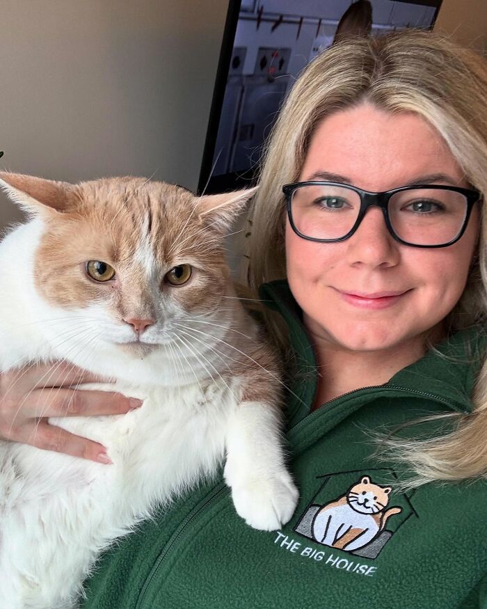 Mujer sosteniendo un gato que solía tener sobrepeso, tanto que aparecía contenido como saludable.