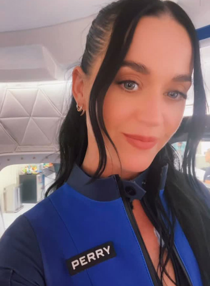 Katy Perry en un traje de vuelo de origen azul, posando dentro de una nave espacial antes de su experiencia en vuelo espacial.