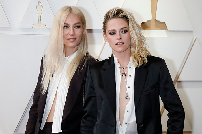 Los tortolitos Kristen Stewart y Dylan Meyer posan juntos en un evento, vestidos con elegantes atuendos en blanco y negro.