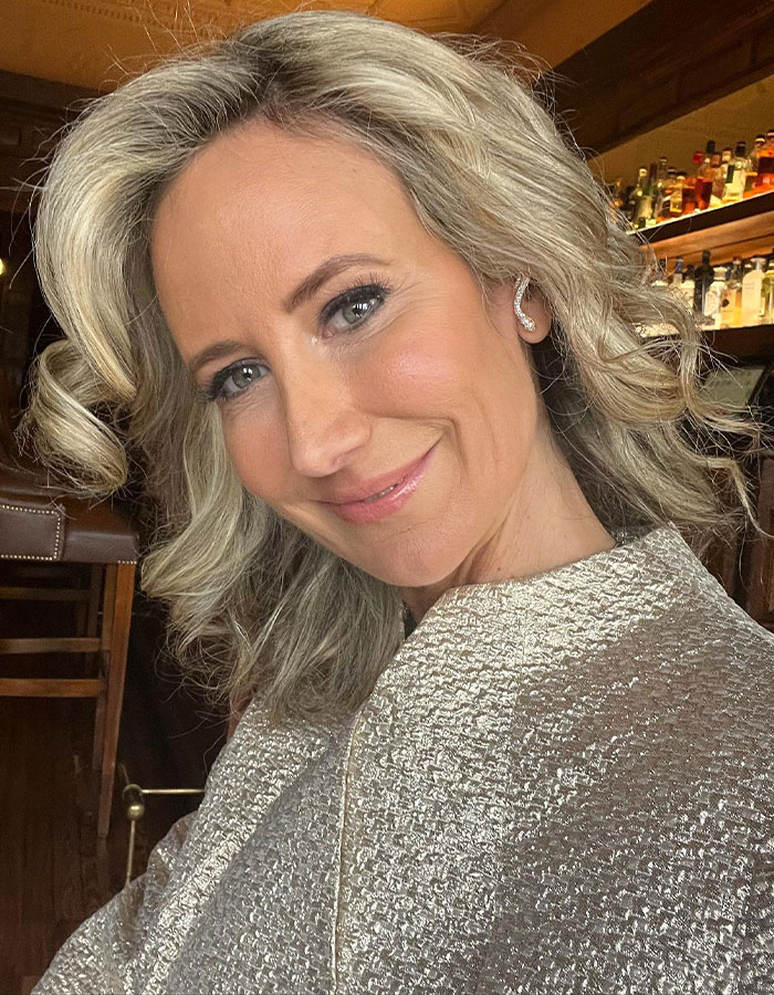 Mujer rubia sonriendo en el interior, relacionado con la ex controversia del Príncipe Andrew.