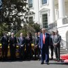 En esta foto, el presidente Trump se encuentra fuera de la Casa Blanca con un auto de carrera amarillo y varios pilotos de autos de carrera y propietarios de equipos.