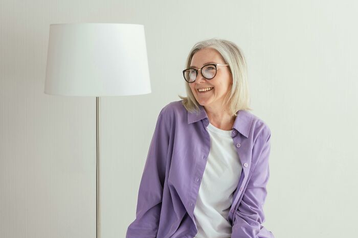 Smiling Anday Woman con gafas sentadas junto a una lámpara, simbolizando el secreto humano y de longevidad más antiguo del mundo.