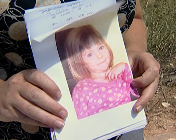 Persona que sostiene una foto de Madeleine McCann con una camisa de lunares rosa relacionada con la solicitud urgente de la policía alemana.