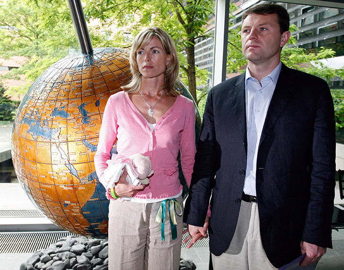 Pareja parada cerca del mundo grande en el interior, una mujer que sostiene una muñeca, relacionada con la solicitud urgente de la policía alemana de Madeleine McCann.