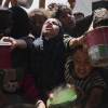 Los palestinos luchan por obtener comida donada en una cocina comunitaria en Khan Younis, Strip Gaza, el lunes.