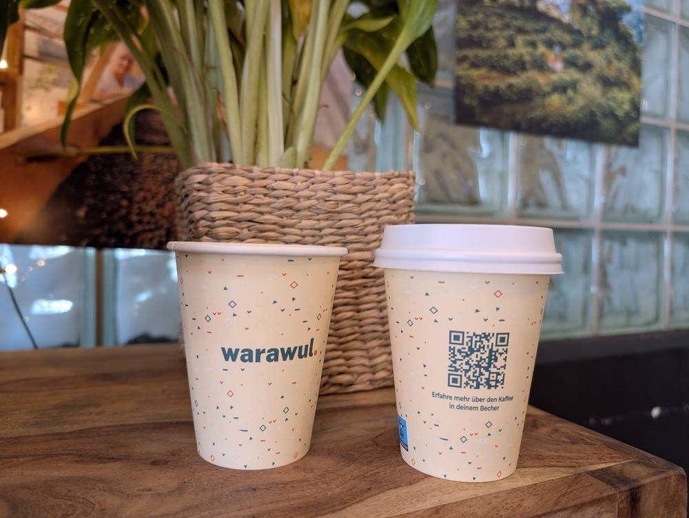 Transparencia en el café: las tazas de café para llevar se sientan en una mesa de madera. Uno dice