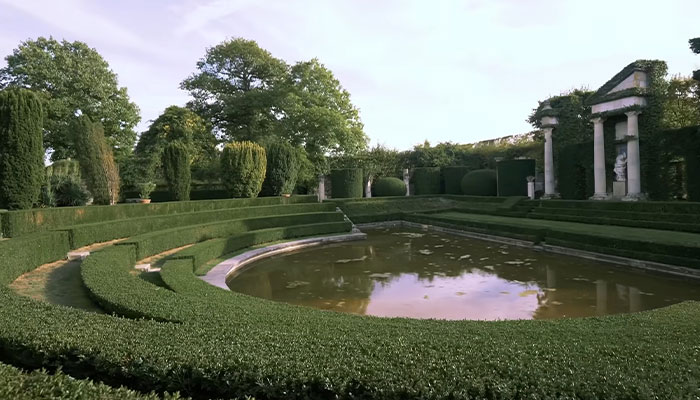 Garden lujoso con setos cuidados y un gran estanque en la casa más cara del mundo con un precio de 10 cifras.