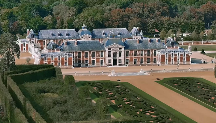 Vista aérea de la casa más cara del mundo rodeada de extensos jardines y paisaje boscoso.