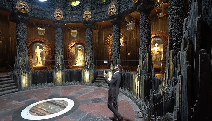 Man in Suit que explora el interior de la casa más caro del mundo con estatuas y un diseño arquitectónico único.