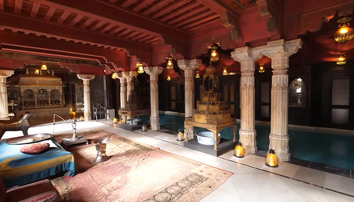 El interior lujosamente decorado de la casa más cara del mundo con pilares ornamentados, madera intrincada e iluminación ambiental.