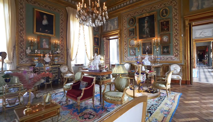 El lujoso interior de la casa más cara del mundo con muebles adornados, candelabros y pinturas clásicas en las paredes.