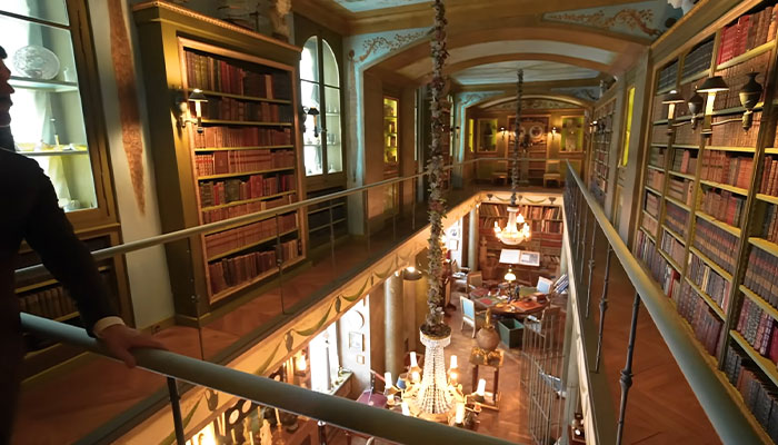 El lujoso interior de la casa más cara del mundo con grandes estanterías, lámparas de araña y elegantes detalles arquitectónicos.
