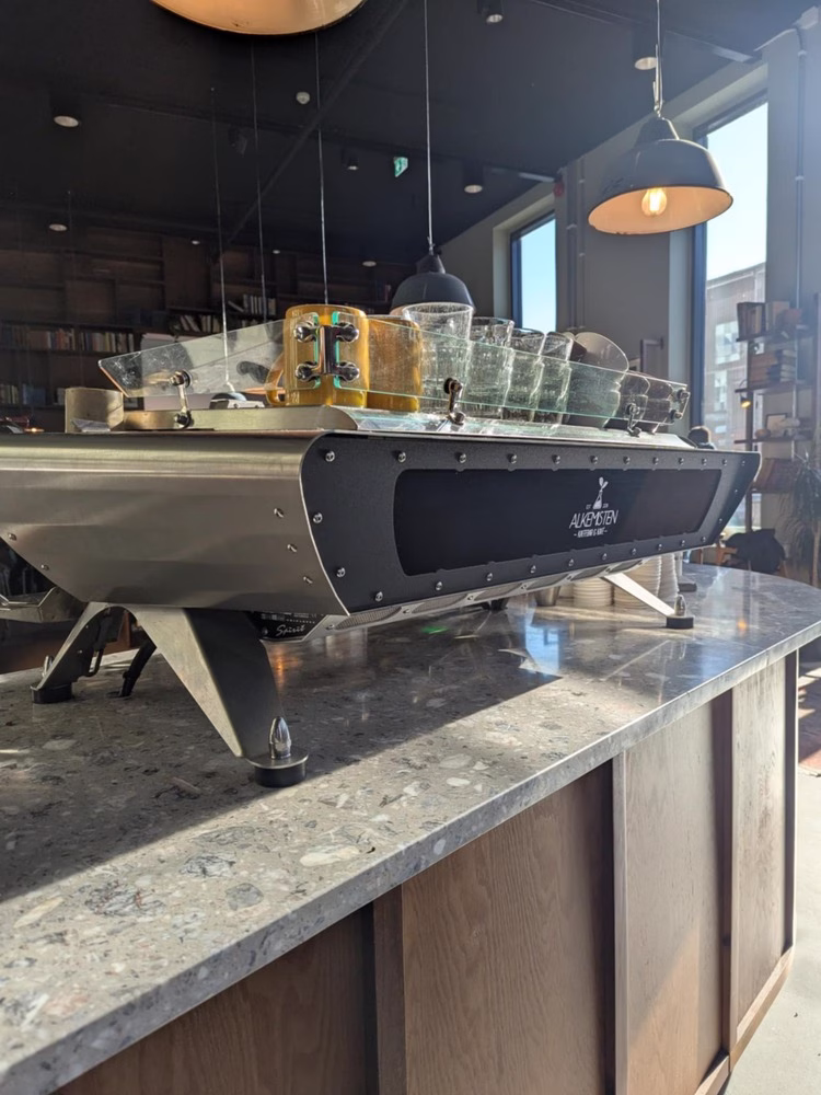 En un café en Gotemburgo, Suecia, una encimera de mármol contiene una máquina de café espresso negra que dice