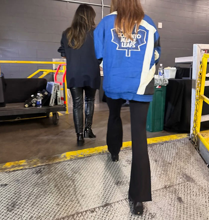 Hailey Bieber caminando en el interior con una chaqueta Toronto Maple Leafs después del berrinche del juego de hockey de su esposo Justin.