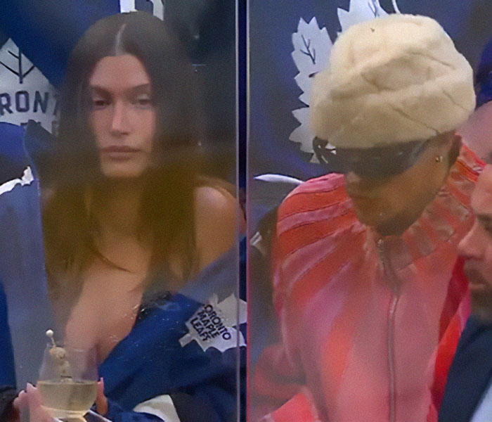 Hailey Bieber visto en un juego de hockey, vistiendo una chaqueta Toronto Maple Leafs, junto a otro espectador con un sombrero blanco y gafas de sol.