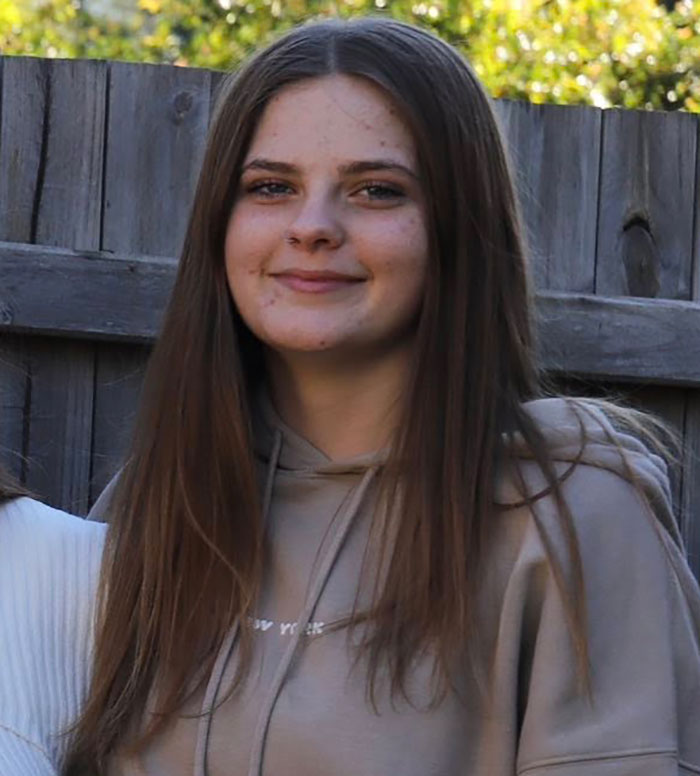 Adolescente sonriendo al aire libre en sudadera casual, relacionado con el texto final de la adolescente desaparecida que desapareció en su camino al aeropuerto