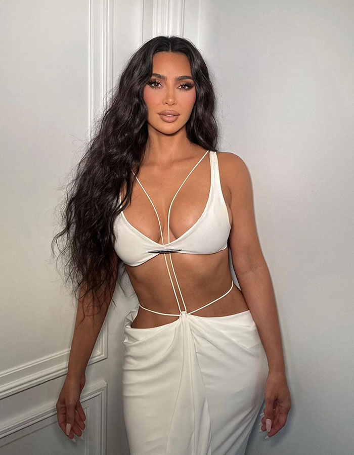 Kim Kardashian posando con un atuendo blanco en una foto de retroceso provocando discusiones sobre sus cirugías de plástico.