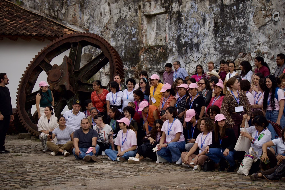 Bean Voyage: un gran grupo de mujeres posa para una foto, muchas de ellas con sombreros rosados.
