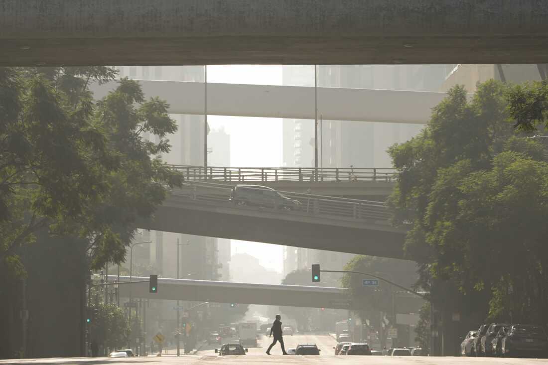 Una persona cruza una calle mientras el smog llena el aire el miércoles 4 de diciembre de 2024 en Los Ángeles.