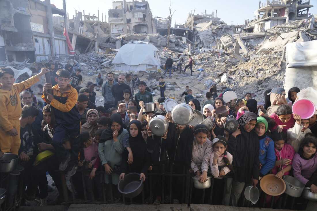 Los palestinos esperan comida donada en un centro de distribución en Beit Lahiya, Northern Gaza Strip, domingo 16 de marzo de 2025.