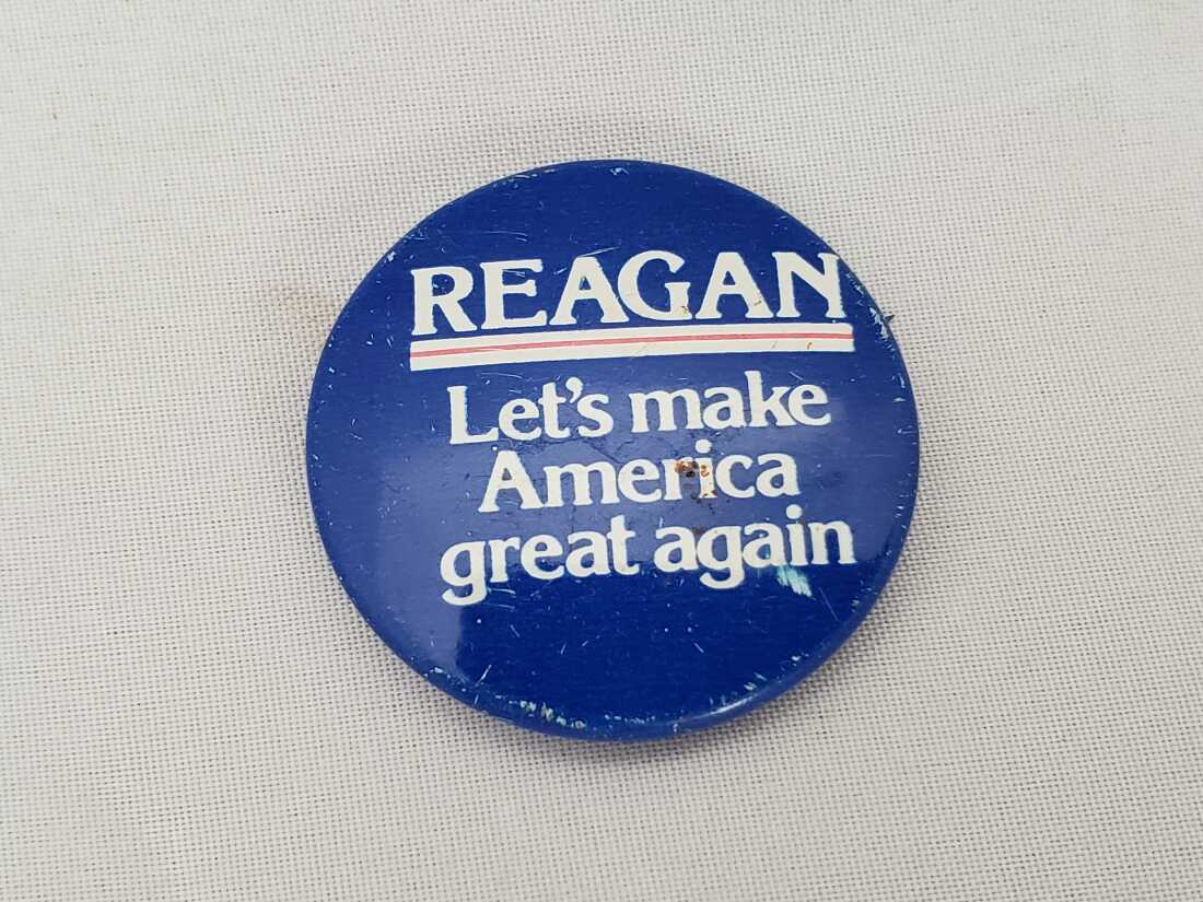 Foto de primer plano del botón Pinback con Text Reading Reagan, vamos a hacer que Estados Unidos sea genial nuevamente, para la campaña electoral presidencial de Ronald Reagan de 1980.