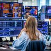La gente mira las pantallas de la computadora que muestran existencias.