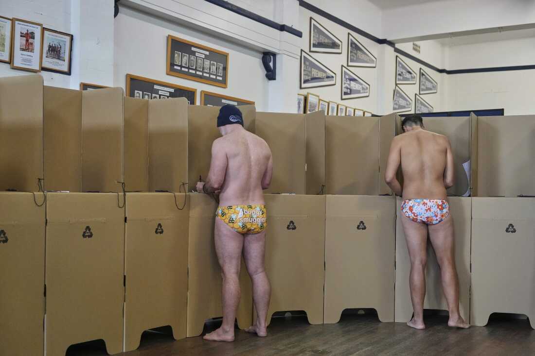 La gente vota en una cabina de votación en la playa de Bondi de Sydney, el sábado 3 de mayo de 2025.