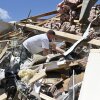 Anthony Broughton cava a través de los escombros de su casa destruida después de una tormenta severa en Londres, Kentucky, el sábado.