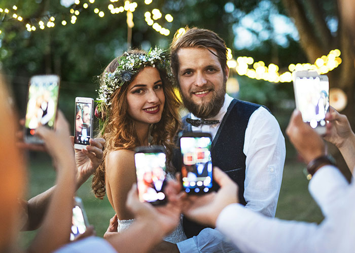 Novias y novios posando para fotos de bodas al aire libre, destacando la venganza y la controversia de la boda de la mujer.