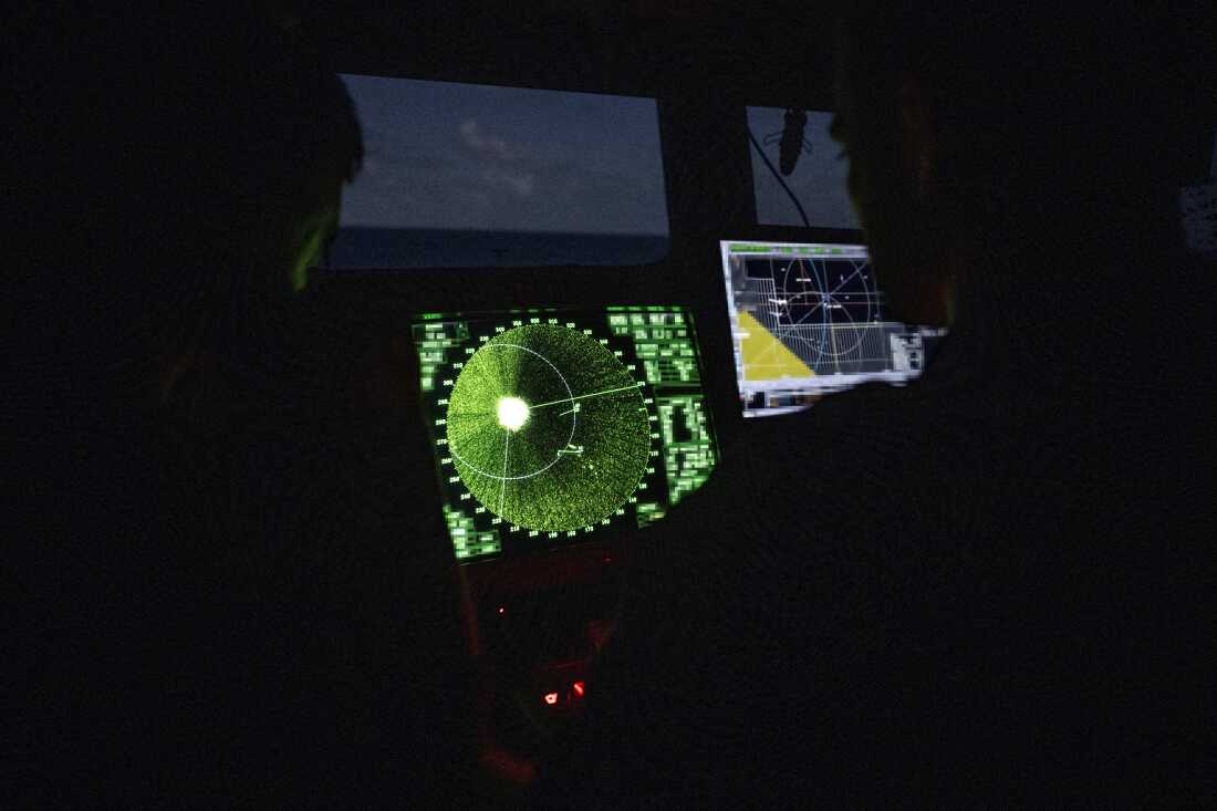 Los miembros del radar de monitor de la Armada francesa en el puente de control en condiciones de poca luz durante una misión de intercepción antidrogas por la fragata de vigilancia francesa FS Ventose navegando en la isla caribeña francesa de Martinica, el 16 de noviembre de 2024.