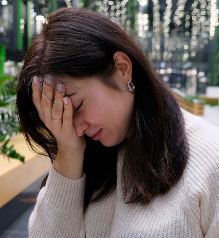 Mujeres que parecen estresadas con la mano en su rostro, simbolizando la frustración por el seguimiento del teléfono y los problemas de privacidad de la ubicación.