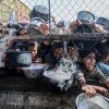 Los palestinos desplazados, incluidas las mujeres y los niños que viven en tiendas de campaña, reciben alimentos distribuidos por organizaciones de ayuda en el distrito de Al Mawasi de Khan Yunis, Gaza, el 30 de mayo de 2025, la situación destaca la creciente desesperación y la necesidad urgente de asistencia humanitaria en el enclave despido.
