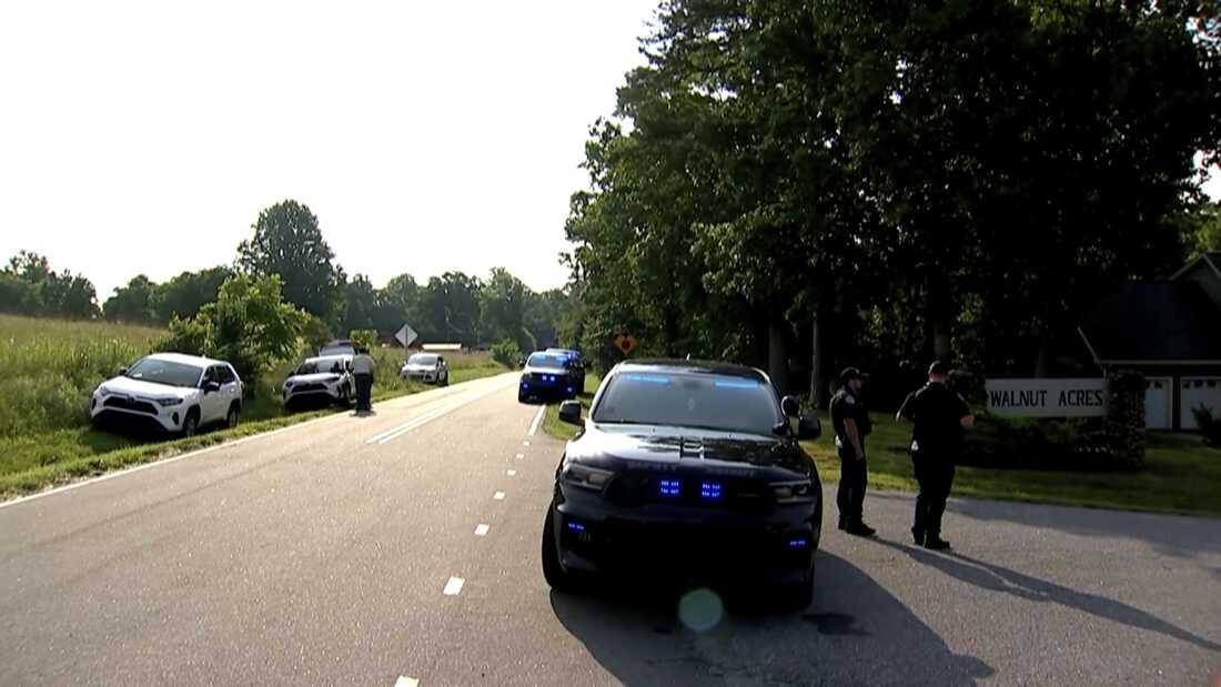 En esta imagen tomada del video de WSOC, varios vehículos policiales se reúnen fuera de una comunidad después de un tiroteo masivo, domingo 1 de junio de 2025, en Hickory, una ciudad en el condado de Catawba, NC (WSOC a través de AP)