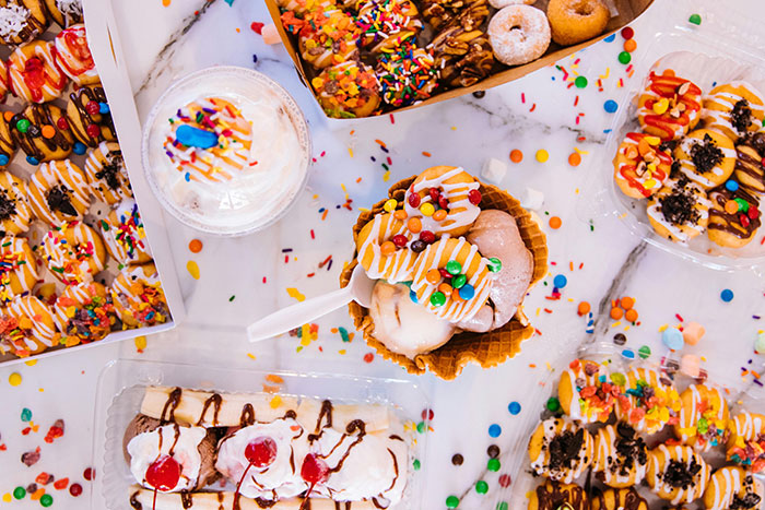 Camisijos coloridos y postres con refrescos dispersos en una mesa, ilustrando a los parientes boomer que socavan los hábitos saludables para niños.