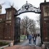 La gente camina por una puerta mientras salen de Harvard Yard en el campus de la Universidad de Harvard en Cambridge, Mass.