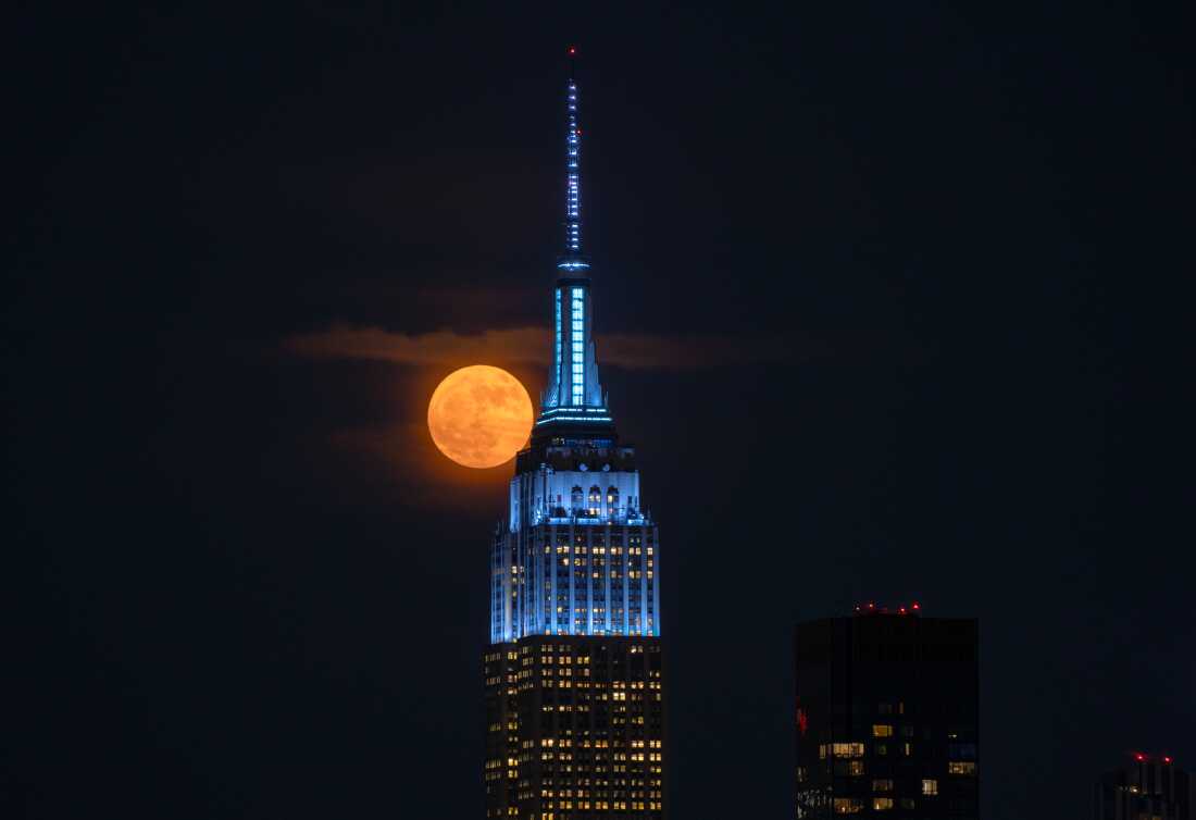 Weehawken, NJ - 10 de junio: La luna de fresa completa se eleva detrás del Empire State Building en la ciudad de Nueva York el 10 de junio de 2025, como se ve en Weehawken, Nueva Jersey. (Foto de Gary Hershorn/Getty Images)