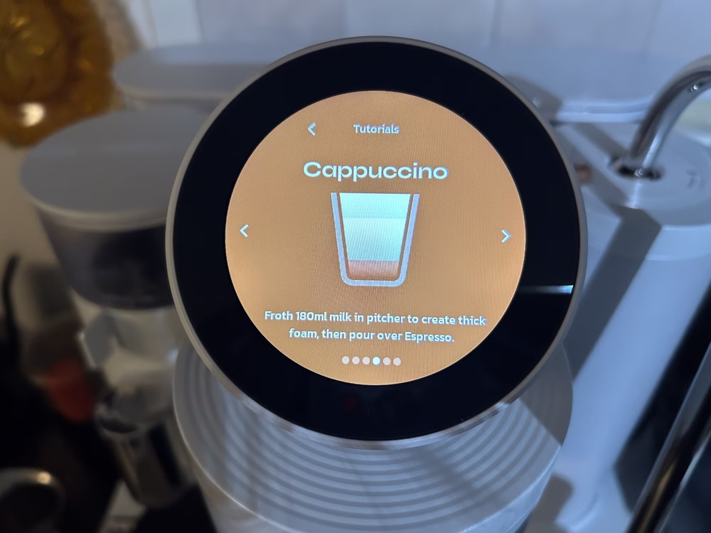 Una foto de la pantalla táctil en la máquina de café espresso de Meraki Home muestra instrucciones sobre cómo hacer un capuchino.