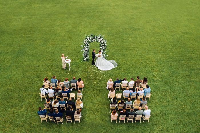 La ceremonia de boda al aire libre con novios bajo el arco floral como mujer tiene suficiente primo insultando su boda.