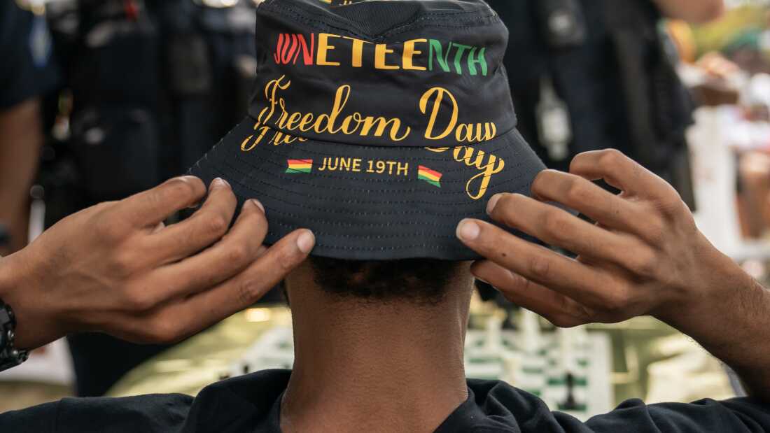 Un asistente ajusta su sombrero de JuneteThmed Durante un vecindario Juneteenth Festival el 17 de junio de 2023, en Washington, DC.