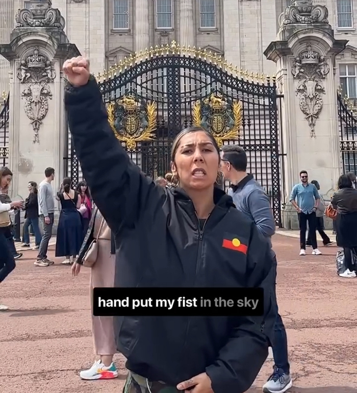Artista aborigen que cría puño y cantando fuera del Palacio de Buckingham, conmovedor debate sobre el rey Charles.