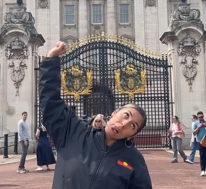 Artista aborigen realizando una canción provocativa en las puertas del Palacio de Buckingham, provocando un debate sobre el rey Charles.