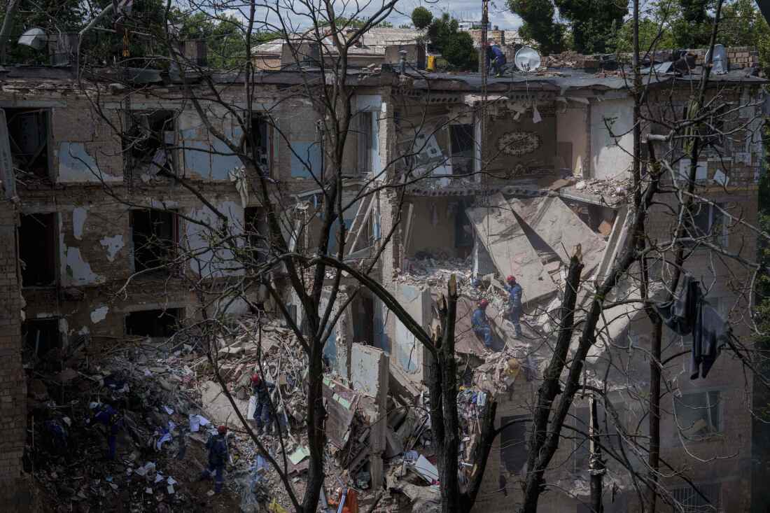 Los trabajadores de los rescate despejan los escombros de una casa residencial destruidas por una huelga rusa en Kiev, Ucrania, el lunes 23 de junio de 2025.