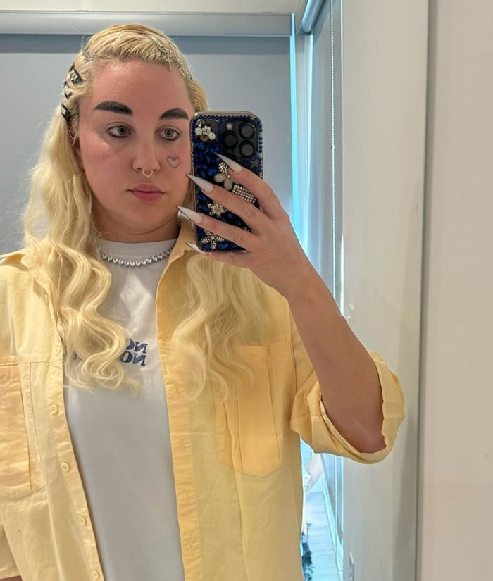 Amanda Bynes tomando una selfie espejo con el pelo largo y rubio, destacando su uso de las reacciones ozempic y pública.