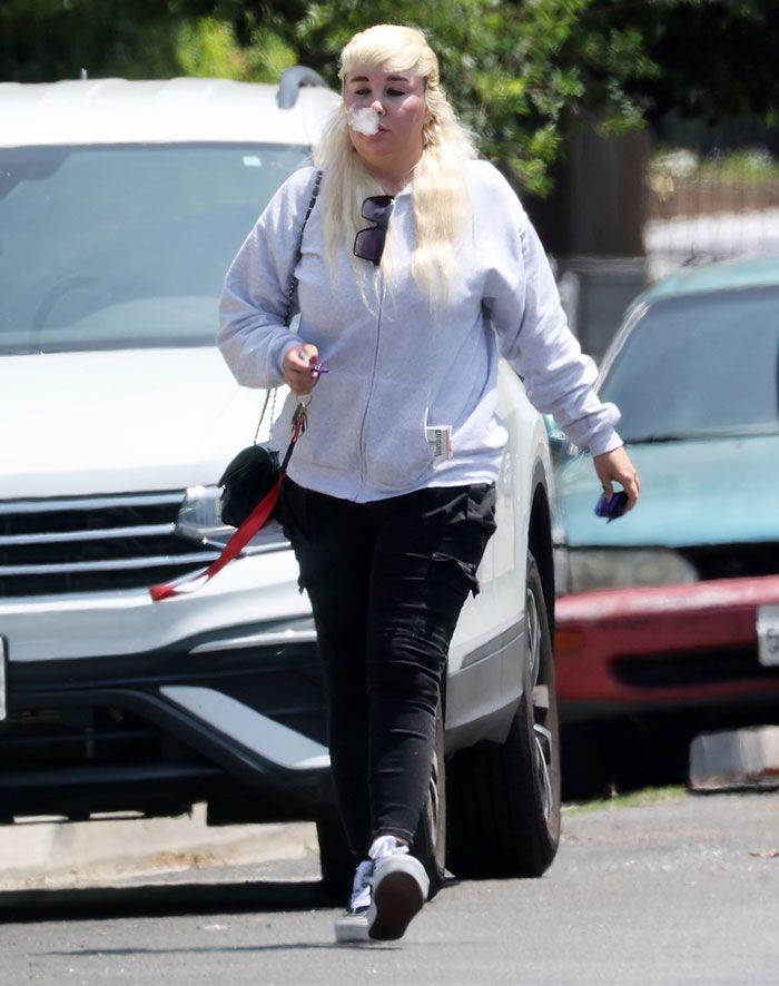 Amanda Bynes sale con ropa informal, exhalando humo mientras provocaba reacciones mixtas sobre el uso de Ozempic.